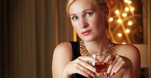 Woman in Cocktail Bar with Glass of Whisky